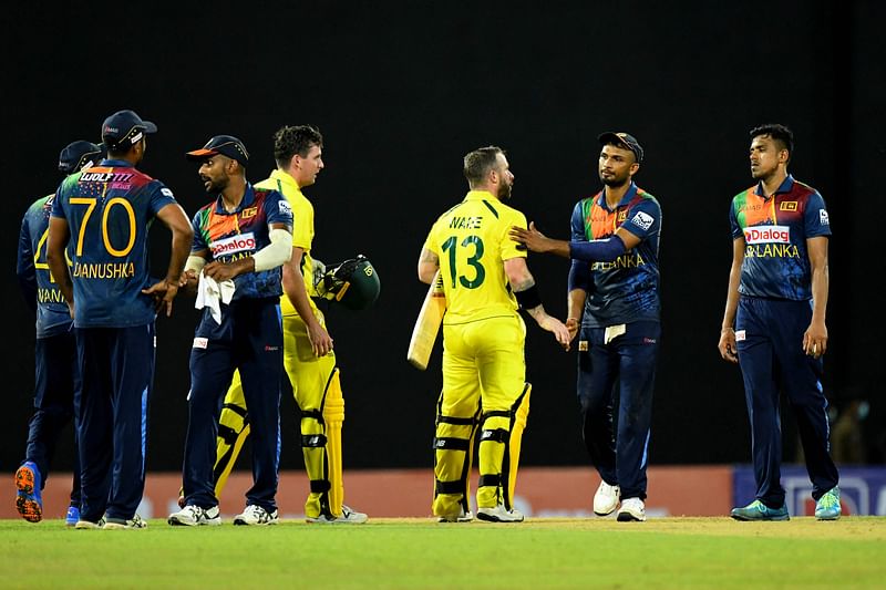 Australia's Matthew Wade (3rd R) and teammate Jhye Richardson (C) shakes hands with Sri Lanka's Captain Dasun Shanaka (2nd R) after Australia won the second Twenty20 international cricket match between Sri Lanka and Australia at the R. Premadasa International Cricket Stadium in Colombo on 8 June, 2022