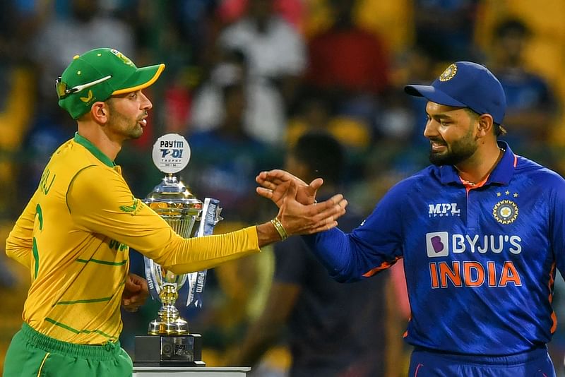 South Africa's Keshav Maharaj (L) greets India's Rishabh Pant during the toss before the start of the fifth Twenty20 international cricket match between India and South Africa at the at M Chinnaswamy Stadium in Bangalore on 19 June, 2022