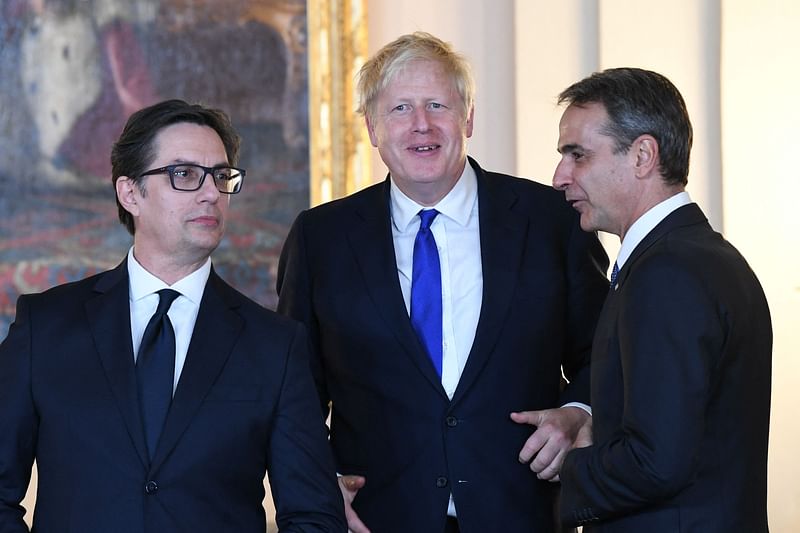 North Macedonia's President Stevo Pendarovski, Britain's Prime Minister Boris Johnson (C) and Greek Prime Minister Kyriakos Mitsotaki talk after a family picture before a dinner hosted by the Spanish royal couple with those invited to the official NATO Summit program at the Royal Palace in Madrid, on 28 June, 2022