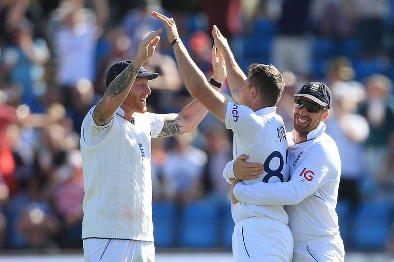 England's Matthew Potts (C) celebrates with England's captain Ben Stokes (L) and England's Jack Leach (R) after taking the wicket of New Zealand's captain Kane Williamson on day 3 of the third cricket Test match between England and New Zealand at Headingley Cricket Ground in Leeds, northern England, on 25 June, 2022