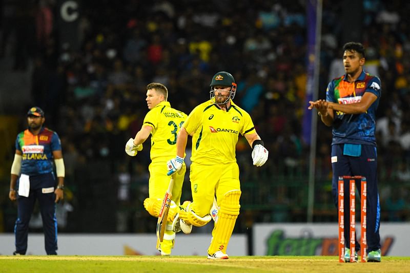 Australia's David Warner (2L) and captain Aaron Finch (2R) run between the wickets during the first Twenty20 international cricket match between Sri Lanka and Australia at the R. Premadasa International Cricket Stadium in Colombo on 7 June, 2022