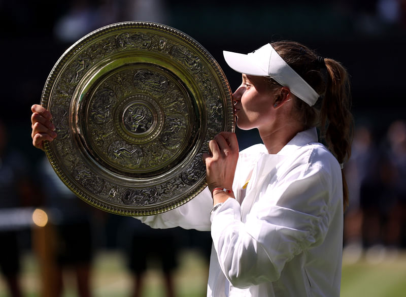 Kazakhstan's Elena Rybakina celebrates with the trophy after winning the women's singles final against Tunisia's Ons Jabeur at the All England Lawn Tennis and Croquet Club, London, Britain on 9 July, 2022