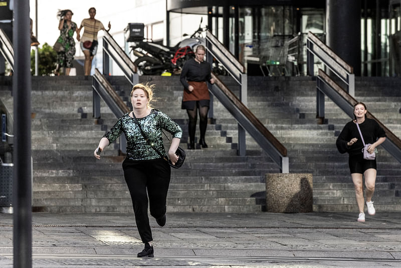 A woman runs in front of the Fields shopping center, after Danish police said they received reports of a shooting at Fields shopping center, in Copenhagen, Denmark on 3 July, 2022