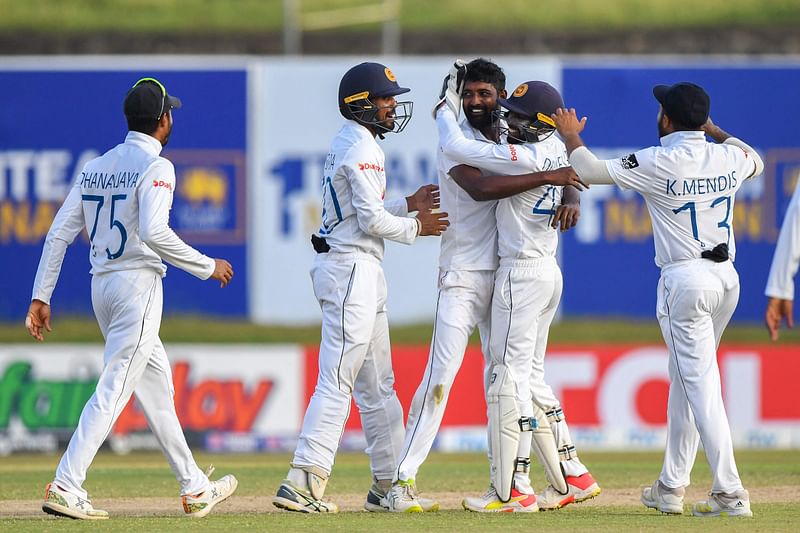 Sri Lanka's Prabath Jayasuriya (C) celebrates with teammates after taking the wicket of Pakistan’s Abdullah Shafique (not pictured) during the first day of play of the first cricket Test match between Sri Lanka and Pakistan at the Galle International Cricket Stadium in Galle on 16 July, 2022