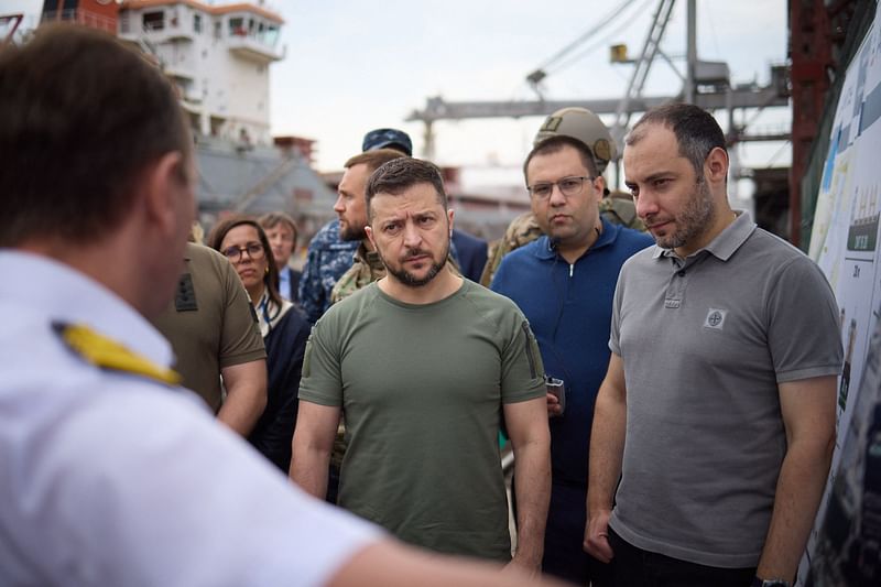 This handout picture taken and released by Ukrainian Presidential Press Service on 29  July, 2022 shows the President Volodymyr Zelensky talking and the Minister of Infrastructure Oleksander Kubrakov (R) listening to officials during a visit to Black Sea port of Chornomorsk