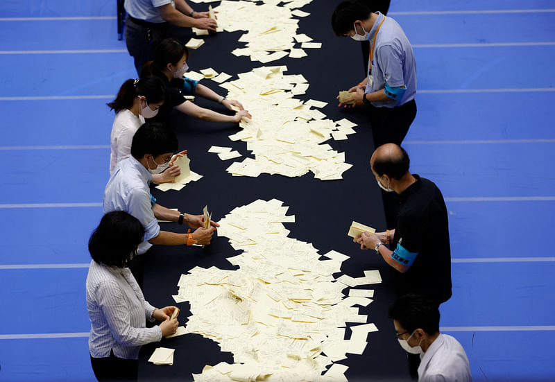 Election officials count votes at a ballot counting centre for Japan's upper house election in Tokyo, Japan, 10 July, 2022.