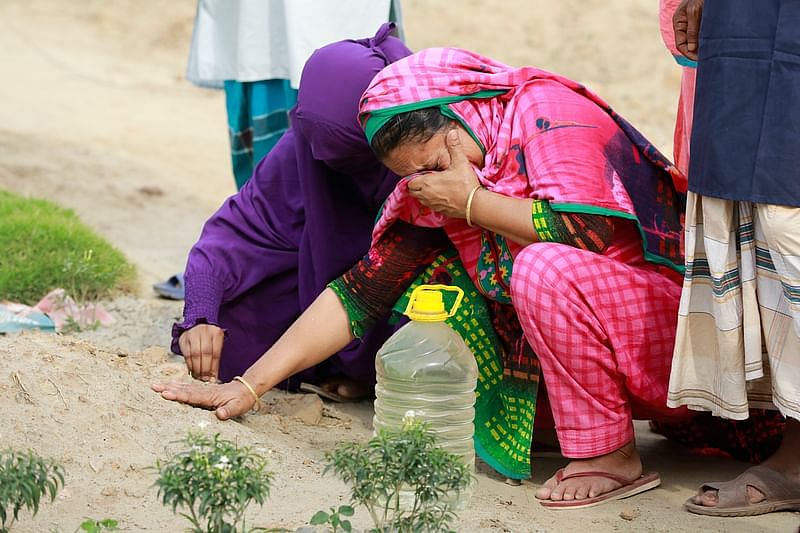 Two women mourn the loss of their relative, who died of Covid-19.