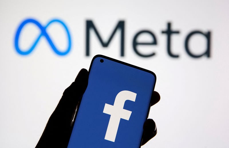 A smartphone with Facebook's logo is seen in front of displayed Facebook's new rebrand logo Meta .