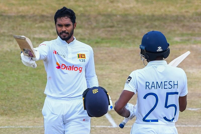 Sri Lanka's Dhananjaya de Silva (L) celebrates after scoring a century (100 runs) as his teammate Ramesh Mendis watches during the fourth day of the second cricket Test match between Sri Lanka and Pakistan at the Galle International Cricket Stadium in Galle on 27 July, 2022