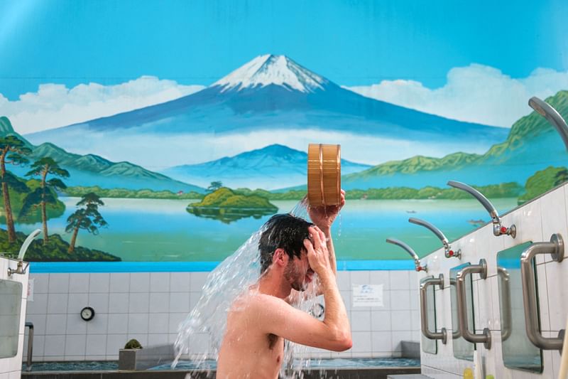 This picture taken on 6 July, 2022 shows renovation activist and co-director of the organisation Sento & Neighborhood Sam Holden taking a bath at the Inariyu, which is a "sento" or public bath, in the Takinogawa area of Tokyo