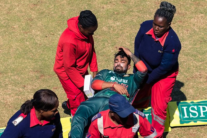 Bangladesh's Litton Das (C) is carried off the field by medical staff after being injured during the first one-day international (ODI) cricket match between Zimbabwe and Bangladesh at the Harare Sports Club on 5 August 2022.