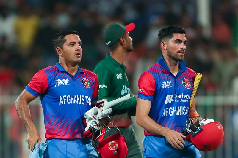 Afghanistan’s Najibullah Zadran (L) and teammate Ibrahim Zadran (R) leave the field after winning the Asia Cup Twenty20 international cricket Group B match between Afghanistan and Bangladesh at the Sharjah Cricket Stadium in Sharjah on 30 August, 2022