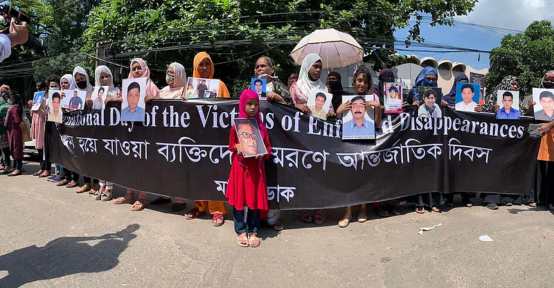 Participants holding photographs of victims of enforced disappearance at human chain in the city's Shahbagh on 30 August 2022