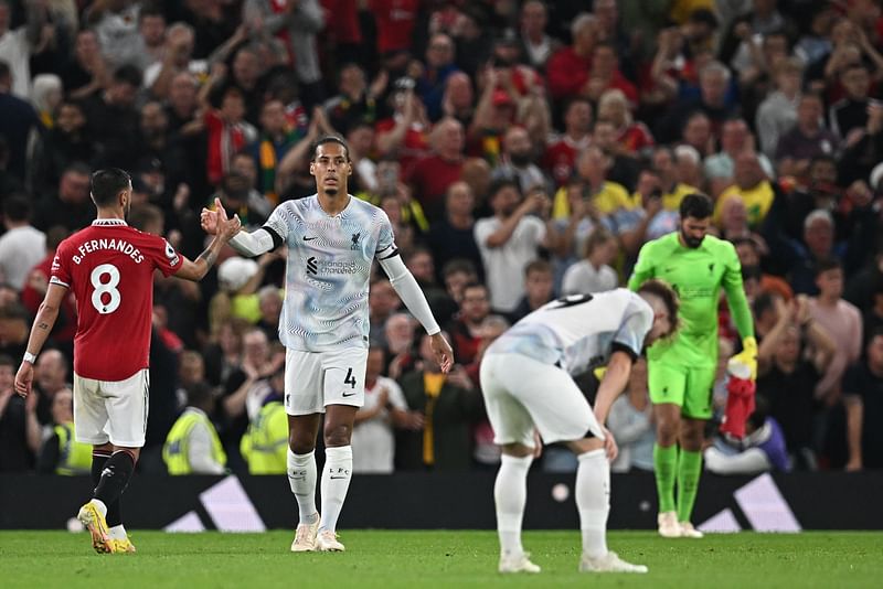 Manchester United's Portuguese midfielder Bruno Fernandes (L) shakes hands with Liverpool's Dutch defender Virgil van Dijk (C) as players react on the pitch after the English Premier League football match between Manchester United and Liverpool at Old Trafford in Manchester, north west England, on 22 August, 2022