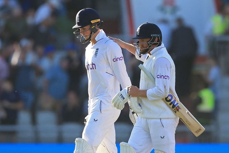 England's Zak Crawley (L) and England's Jonny Bairstow (R) leave after play on day one of the second Test match between England and South Africa at the Old Trafford cricket ground in Manchester on 25 August, 2022