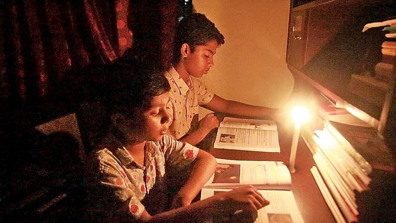 Two students study at night during load shedding in Bogura