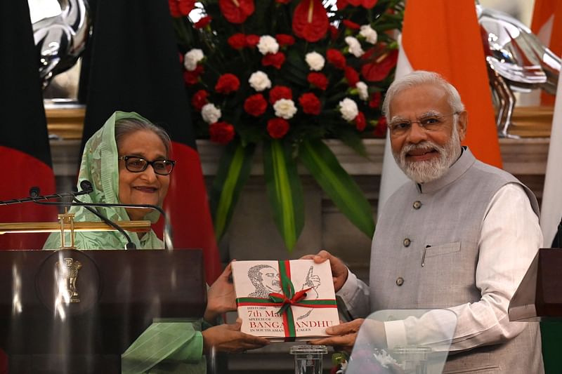 India's Prime Minister Narendra Modi (R) receives a book from his Bangladesh’s counterpart Sheikh Hasina during a joint media briefing at the Hyderabad House in New Delhi on 6 September, 2022