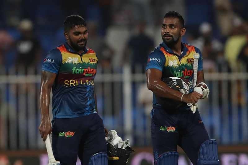 Sri Lanka's Chamika Karunaratne (R) and Wanindu Hasaranga leave the field after winning the Asia Cup Twenty20 international cricket match between Sri Lanka and Afghanistan at the Sharjah Cricket Stadium in Sharjah on 3 September, 2022