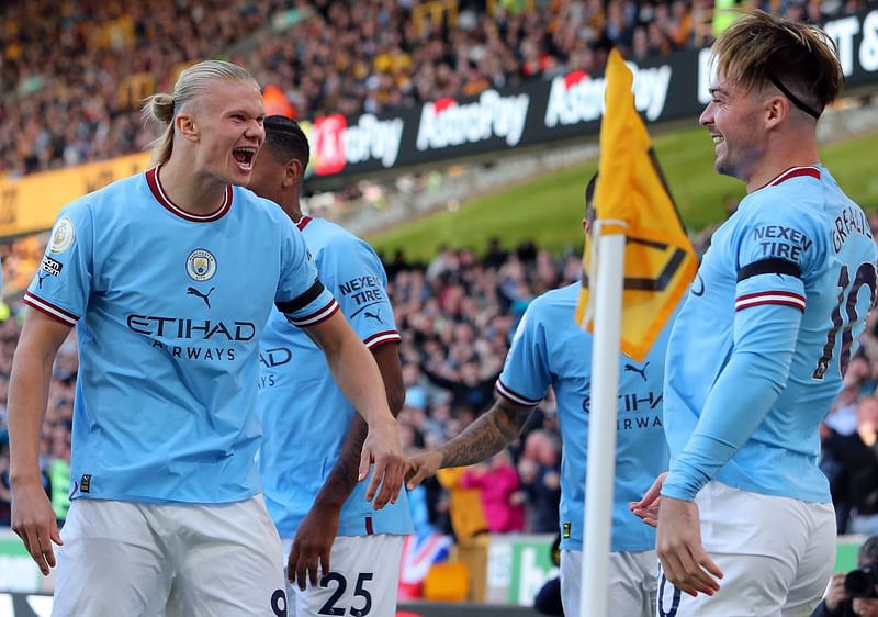 Manchester City's English midfielder Jack Grealish (R) celebrates scoring his team's first goal with Manchester City's Norwegian striker Erling Haaland during the English Premier League football match between Wolverhampton Wanderers and Manchester City at the Molineux stadium in Wolverhampton, central England on 17 September, 2022