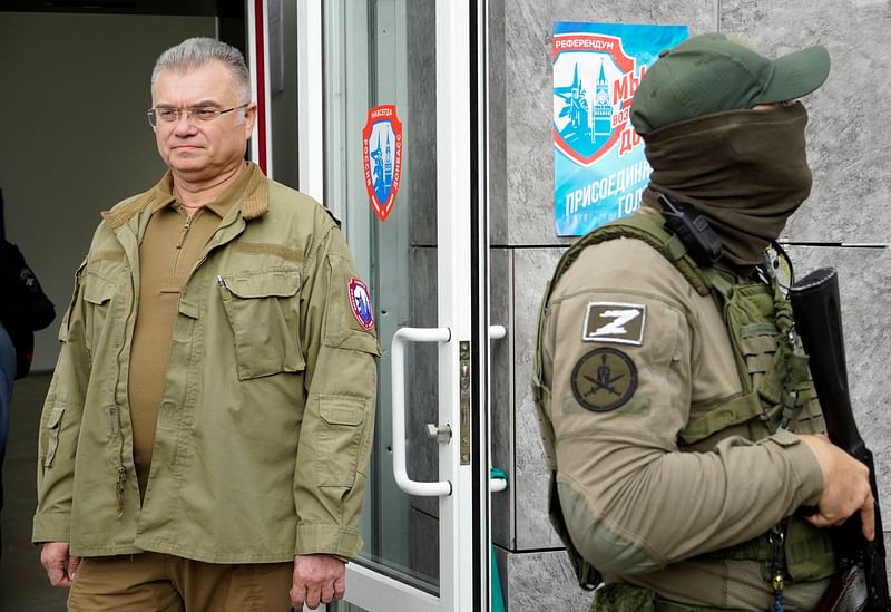 Konstantin Ivashchenko (L), former CEO of the Azovmash plant and appointed pro-Russian mayor of Mariupol, visits a polling station as people vote in a referendum in Mariupol on 27 September, 2022