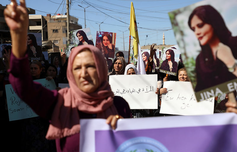 Women carry banners during a protest over the death of 22-year-old Kurdish woman Mahsa Amini in Iran, in the Kurdish-controlled city of Qamishli, northeastern Syria on 26 September, 2022