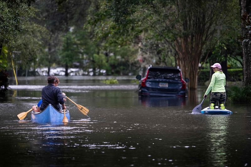 People canoe and paddle board on a flooded street in the aftermath of Hurricane Ian in Orlando, Florida on 29 September, 2022.