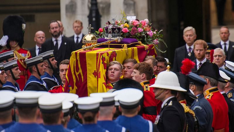 A Bearer Party of The Queen's Company, 1st Battalion Grenadier Guards places the coffin of Queen Elizabeth II, draped in the Royal Standard, onto the State Gun Carriage of the Royal Navy outside Westminster Hall, at the Palace of Westminster in London on 19 September 2022, where it has been Lying in State since 14 September.