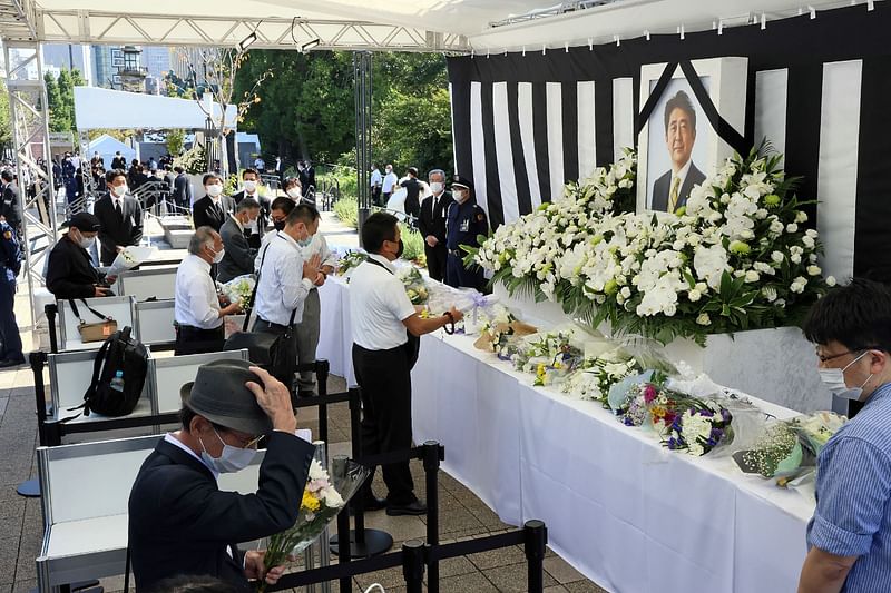 People leave flowers and pay their respects to former Japanese prime minister Shinzo Abe outside the Nippon Budokan in Tokyo on 27 September, 2022