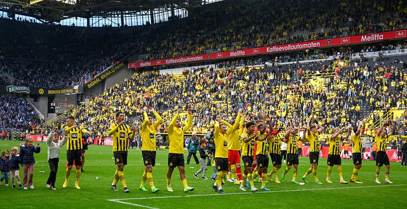 Dortmund's players celebrate with the fans after the German first division Bundesliga football match between BVB Borussia Dortmund and FC Schalke 04 in Dortmund, western Germany, on 17 September, 2022