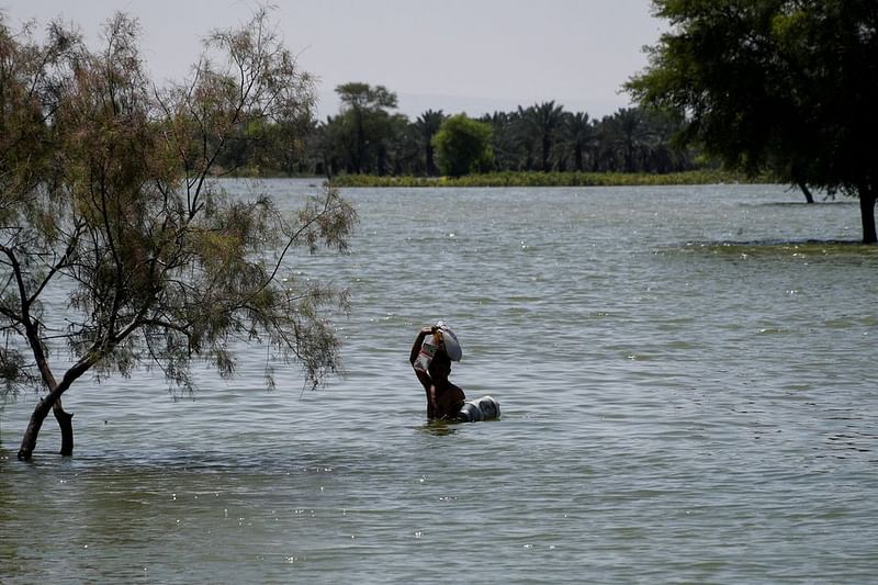 A flood victim wades through flood water, following rains and floods during the monsoon season in Bajara village, Sehwan, Pakistan, on 31 August, 2022.