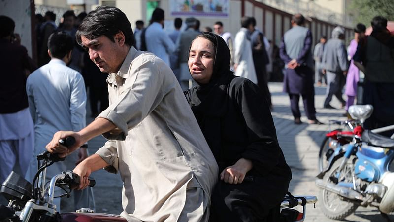 A woman arrives on a motorbike to search for a relative at a hospital in Kabul on 30 September, 2022 after a blast in a learning centre in the Dasht-e-Barchi area of Afghanistan’s capital