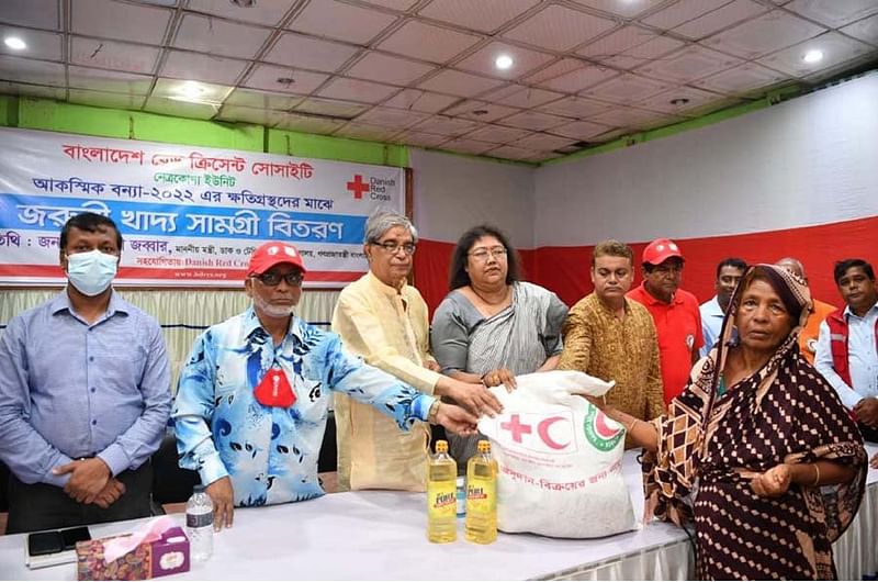 Minister Mustafa Jabbar distributes emergency food items among flood victims in Netrokona.