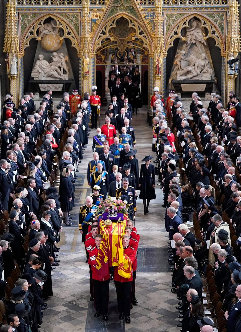 King Charles III, Britain's Camilla, Queen Consort, Britain's Princess Anne, Princess Royal, Vice Admiral Sir Tim Laurence, Britain's Prince Andrew, Duke of York, Britain's Prince William, Prince of Wales and Britain's Catherine, Princess of Wales follow behind the coffin of Queen Elizabeth II, draped in the Royal Standard with the Imperial State Crown and the Sovereign's orb and sceptre, as it is carried out of Westminster Abbey after her State Funeral in London on 19 September 2022.