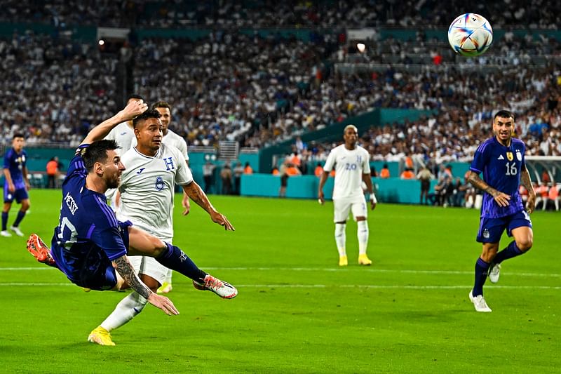 Argentina's Lionel Messi (L) kicks the ball during the international friendly match between Honduras and Argentina at Hard Rock Stadium in Miami Gardens, Florida, on 23 September, 2022