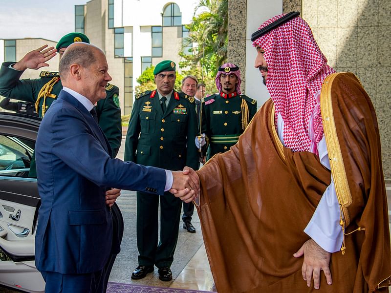 This handout picture provided by the Saudi Royal Palace shows (R to L) Saudi crown prince Mohammed bin Salman shaking hands with Germany's Chancellor Olaf Scholz at al-Salam Palace in the Red Sea coastal city of Jeddah on 24 September, 2022