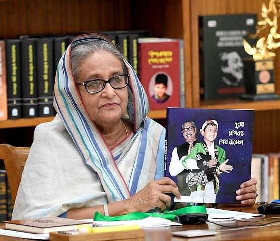 Prime minister Sheikh Hasina holds up a commemorative book published on the occasion of Sheikh Russel's 59th birth anniversary on 18 October, 2022