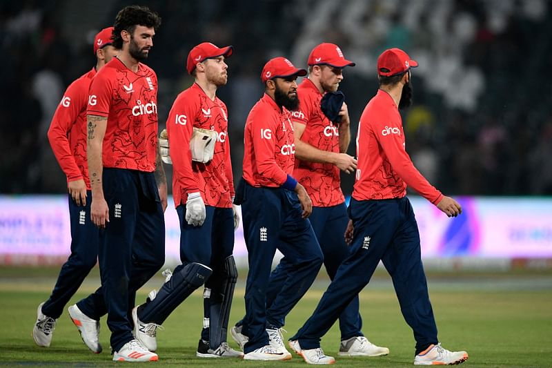 England's players walk back to the pavilion after winning the seventh Twenty20 international cricket match between Pakistan and England at the Gaddafi Cricket Stadium in Lahore on 2 October, 2022