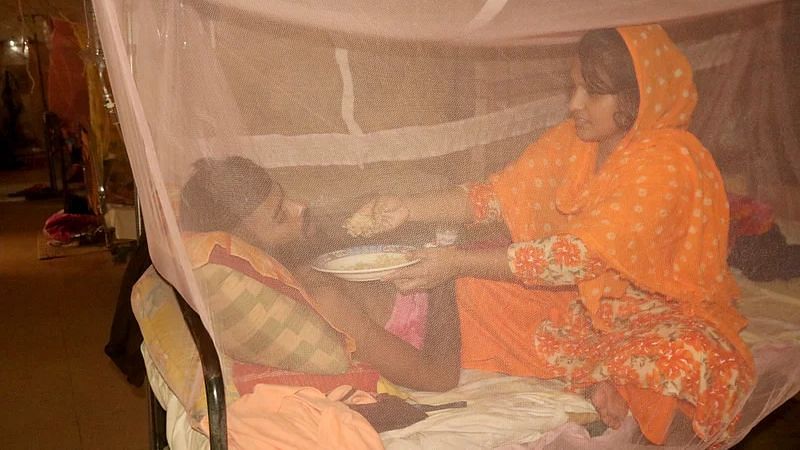 Wife of a worker of Rooppur Nuclear Power Plant feeds him as the worker is suffering from dengue fever and taking treatment at Pabna General Hospital on 7 October 2022