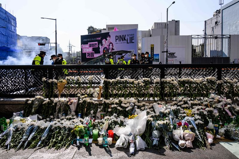 Flowers tributes are seen at a makeshift memorial outside a subway station in the district of Itaewon in Seoul on 31 October, 2022, two days after a deadly Halloween surge in the area