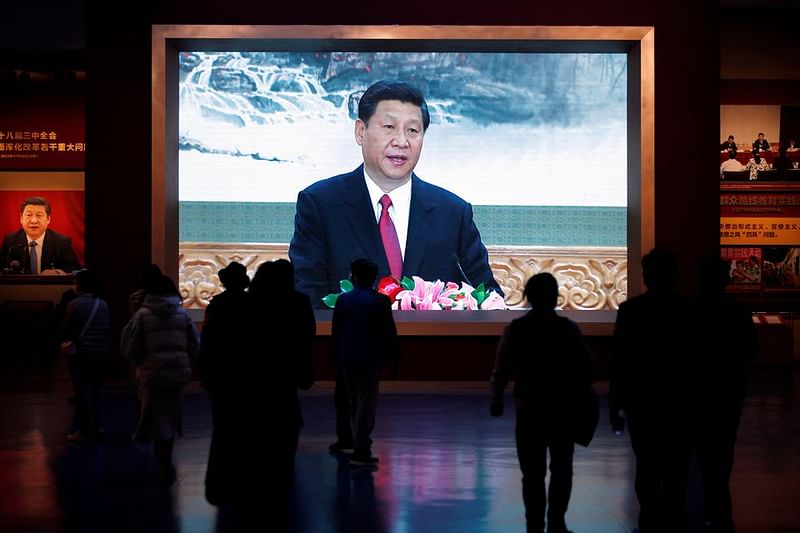 Visitors walk past a screen showing Chinese President Xi Jinping at the Museum of the Communist Party of China in Beijing, China 13 October, 2022.