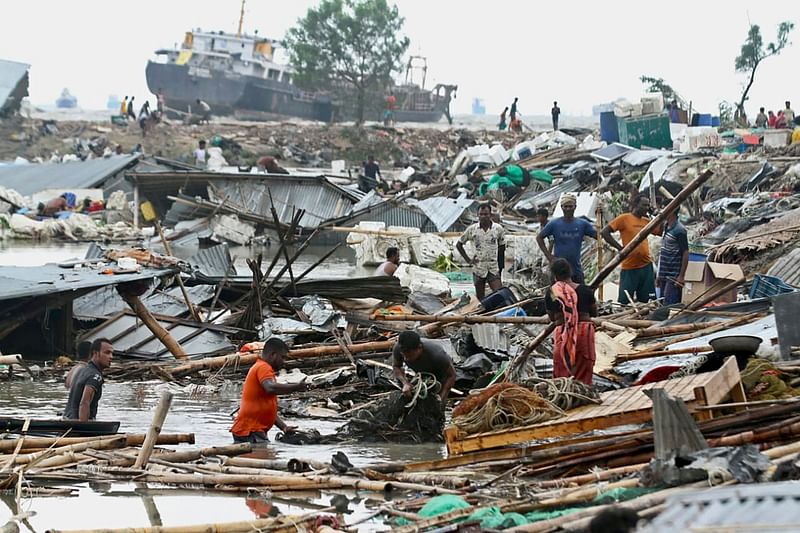 Residents search for their belongings amid the debis of their collapsed huts after the cyclone Sitrang hits in Chittagong on 25 October, 2022