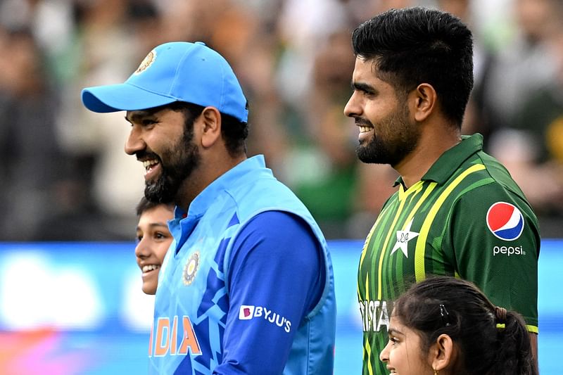 Pakistan's Captain Babar Azam (R) and India's captain Rohit Sharma walk into the ground during the ICC men's Twenty20 World Cup 2022 match between India and Pakistan at Melbourne Cricket Ground (MCG) in Melbourne on 23 October, 2022