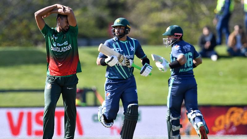 Bangladesh's Mustafizur Rahman (L) reacts as Pakistan's Iftikhar Ahmed (C) and Mohammad Rizwan run between the wickets during the first match between Pakistan and Bangladesh in the Twenty20 tri-series at Hagley Oval in Christchurch on 7 October, 2022