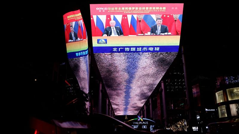 A giant screen broadcasts news footage of a virtual meeting between Chinese President Xi Jinping and Russian President Vladimir Putin, at a shopping mall in Beijing, China, on 15 December, 2021