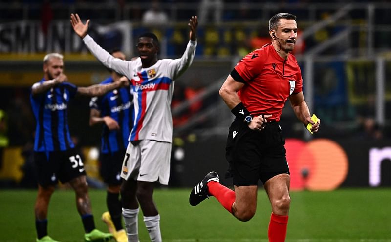 Slovenian referee Slavko Vincic runs across the pitch after giving a yellow card during the UEFA Champions League Group C football match between Inter Milan and FC Barcelona on 4 October, 2022 at the Giuseppe-Meazza (San Siro) stadium in Milan