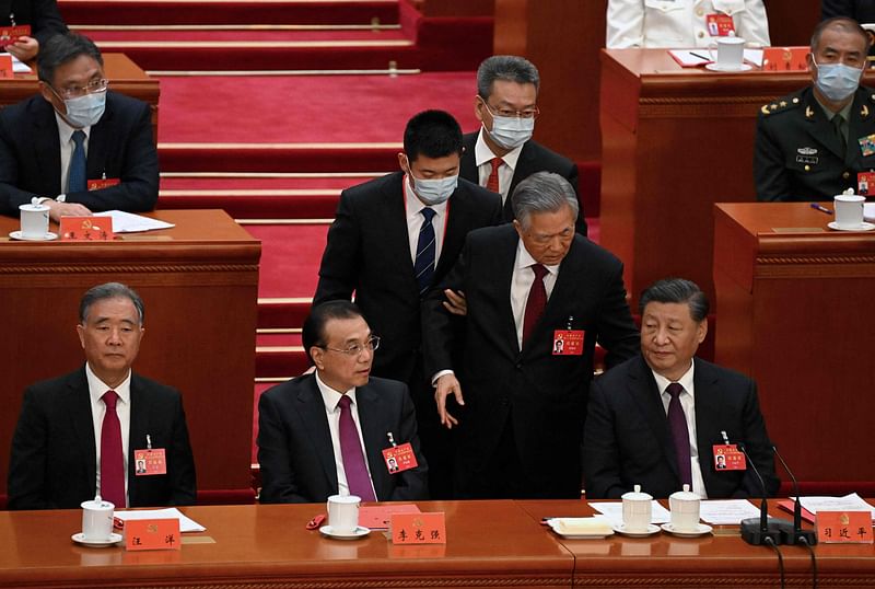 China's President Xi Jinping (R) sits besides premier Li Keqiang (2L) as former president Hu Jintao (2R) is assisted to leave from the closing ceremony of the 20th China's Communist Party's congress at the Great Hall of the People in Beijing on 22 October, 2022