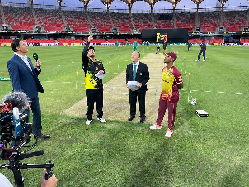 Australia captain Aaron Finch flips the coin as his West Indies counterpart Nicholas Pooran looks on in Goal Coast, Australia on 5 October, 2022