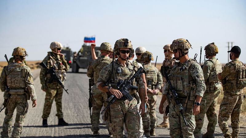 Soldiers of a Russian military convoy and their US counterparts exchange greetings as their patrol routes intersect in an oil field near Syria's al-Qahtaniyah town in the northeastern Hasakah province, close to the border with Turkey, on 8 October, 2022