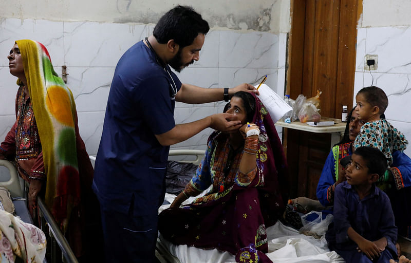 Naveed Ahmed, 30, a doctor, gives medical assistance to flood-affected girl Hameeda, 15, suffering from malaria at Sayed Abdullah Shah Institute of Medical Sciences in Sehwan, Pakistan September 29, 2022