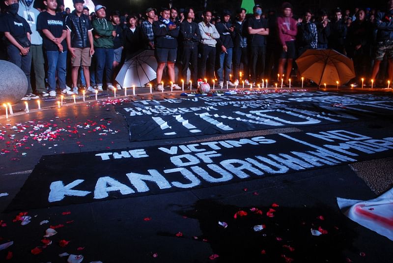 This picture taken in Bandung on 2 October, 2022 shows football supporters attending a candlelight vigil for victims of a stampede at Kanjuruhan stadium in the city of Malang